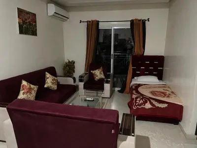 a living room with a couch and a bed at 1er étage numéro 5 avec balcon POUR FAMILLE in Marrakech