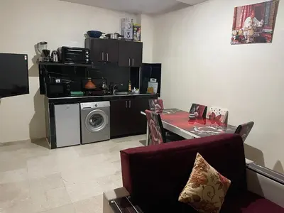 a kitchen with a table and a washing machine at 1er étage numéro 5 avec balcon POUR FAMILLE in Marrakech