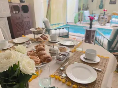 a table with pastries and cups and plates on it at RIAD DAR NAOMI in Marrakech