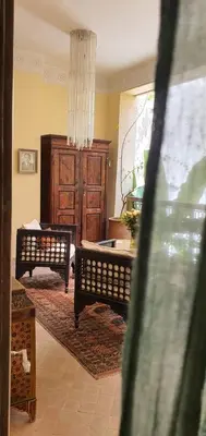 a living room with two benches and a chandelier at RIAD DAR NAOMI in Marrakech