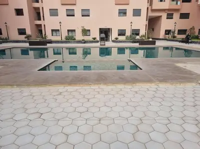 a swimming pool in front of a building at Appartement résidence Marrakech haut standing piscine in Marrakech