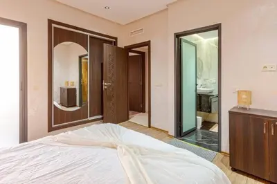 a bedroom with a bed and a bathroom with a sink at Appartement résidence Marrakech haut standing piscine in Marrakech