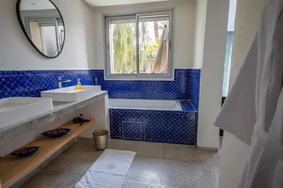 a bathroom with a sink and a tub and a window at Villa Fima Kech in Marrakech