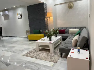 a living room with a couch and a table at Appartement en Duplex avec 3 chambres Haut Standing Gueliz Marrakech in Marrakech
