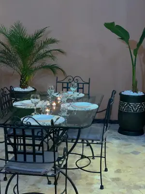 a table with chairs and a table with wine glasses at Appartement en Duplex avec 3 chambres Haut Standing Gueliz Marrakech in Marrakech