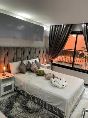 a bedroom with a large bed with a large window at Appartement en Duplex avec 3 chambres Haut Standing Gueliz Marrakech in Marrakech