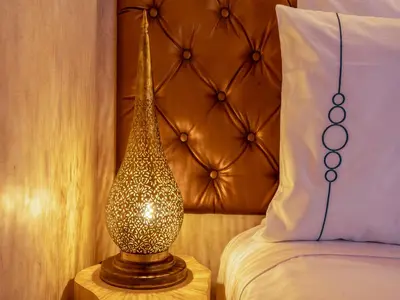 a lamp sitting on a table next to a bed at Riad Zehar 79 & Spa in Marrakech