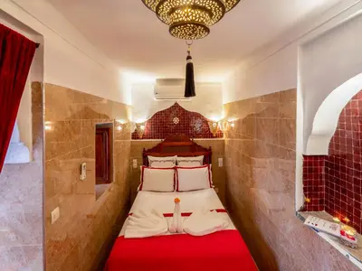 a bedroom with a bed with a red blanket at Riad Zehar 79 & Spa in Marrakech