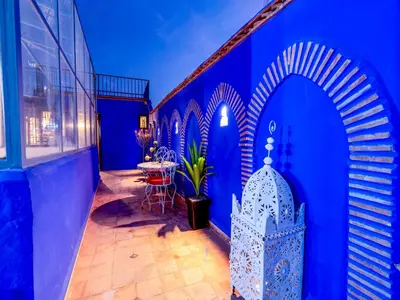 a room with blue walls and a table and chairs at Riad Zehar 79 & Spa in Marrakech