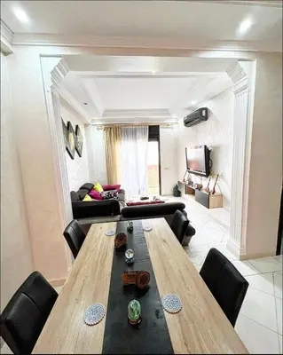 a living room with a wooden table and a couch at Nice new apartment in the city center in Marrakech