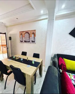 a dining room with a table and a couch at Nice new apartment in the city center in Marrakech