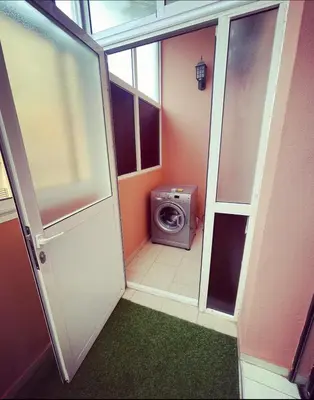 a small bathroom with a washing machine and a door at Nice new apartment in the city center in Marrakech
