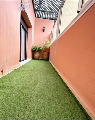 an empty hallway with green grass in a building at Nice new apartment in the city center in Marrakech