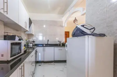 a kitchen with white cabinets and a white refrigerator at Appartement 2 chambres in Marrakech