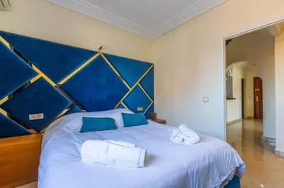 a large bed with a blue headboard in a bedroom at Appartement 2 chambres in Marrakech