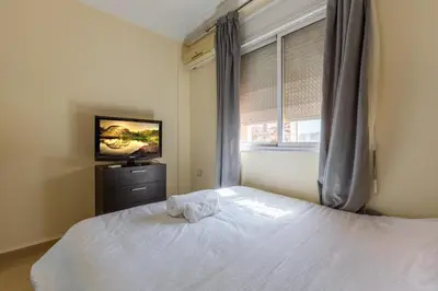 a bedroom with a white bed and a television at Appartement 2 chambres in Marrakech