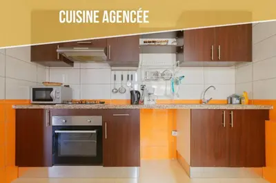 a kitchen with brown cabinets and a microwave at Residence DES LILAS DAR SALAM chez Madame ASSYL residence avec 3 piscines in Marrakech