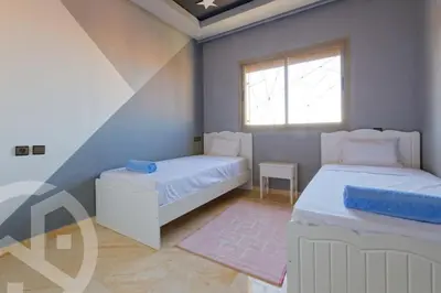 a bedroom with two beds and a window at Residence DES LILAS DAR SALAM chez Madame ASSYL residence avec 3 piscines in Marrakech