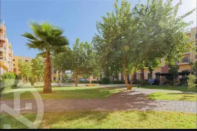 a park with two palm trees and a building at Residence DES LILAS DAR SALAM chez Madame ASSYL residence avec 3 piscines in Marrakech