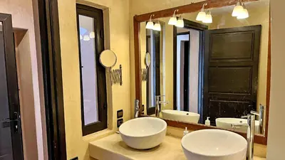 a bathroom with two sinks and a large mirror at Riad Pourpre Medina in Marrakech