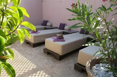 a living room with couches and plants at Riad Pourpre Medina in Marrakech