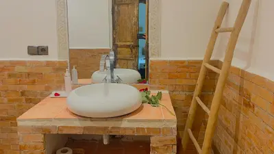 a bathroom with a sink on a brick wall at Riad Pourpre Medina in Marrakech