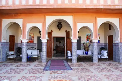 a courtyard with arches and furniture in a building at Riad Ben in Marrakech