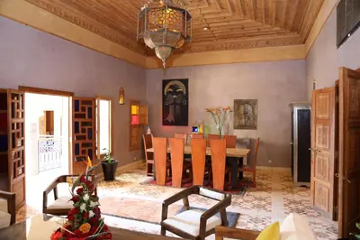 a dining room with a table and a chandelier at Riad Ben in Marrakech