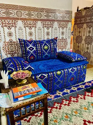 a living room with a blue couch and a table at Calm appartment close to airport of Marrakech in Marrakech