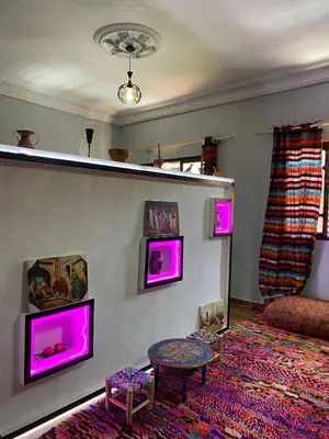 a living room with purple lights on the wall at Calm appartment close to airport of Marrakech in Marrakech