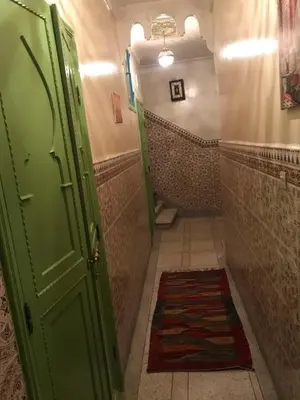 a bathroom with a green door and ailed hallway at Dar Khadija Familly in Marrakech