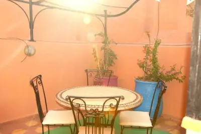 a table and chairs in a room with plants at Dar Khadija Familly in Marrakech