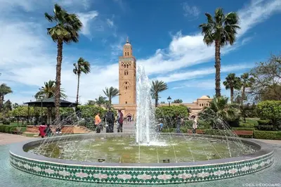a fountain in front of a building with a clock tower at Dar Khadija Familly in Marrakech