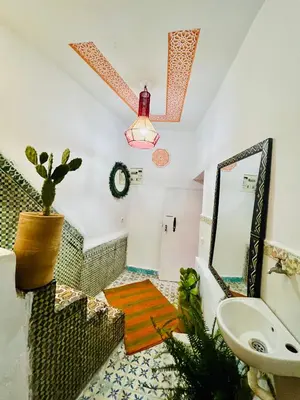 a bathroom with a sink and a mirror at Dar jamaa lfna in Marrakech