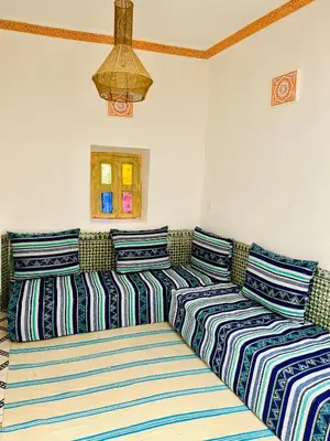 three beds in a room with striped pillows at Dar jamaa lfna in Marrakech