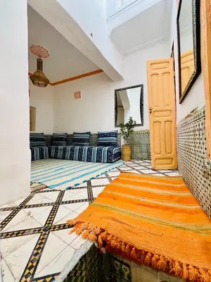 a living room with a couch and a rug on the floor at Dar jamaa lfna in Marrakech