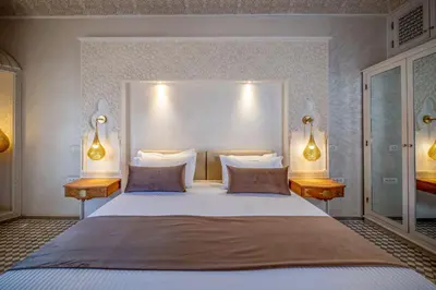 a bedroom with a large white bed with two lamps at Riad Glatt K in Marrakech