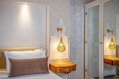 a bedroom with a bed and two lights on the wall at Riad Glatt K in Marrakech