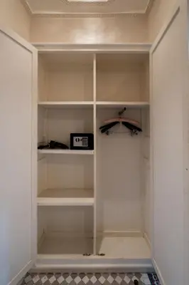 a walk in closet with white shelves and a clock at Riad Glatt K in Marrakech
