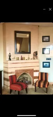 a living room with two chairs and a fireplace at appaartement M23 premium village in Marrakech