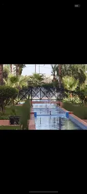 a large swimming pool with people in the water at appaartement M23 premium village in Marrakech