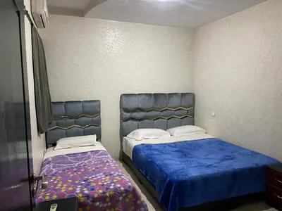 two beds in a small room with blue sheets at Appartement 17 3ème étage avec balcon POUR FAMILLE in Marrakech