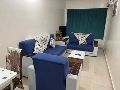 a living room with blue chairs and a table at Appartement 1er étage numéro 6 POUR FAMILLE in Marrakech