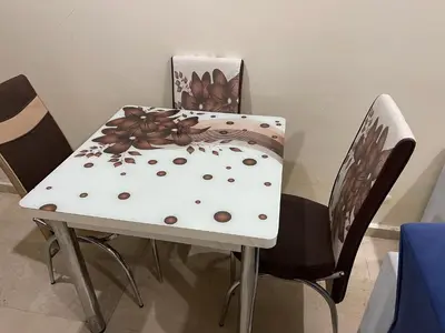 a table and chairs with a white table and a table and chairs at Appartement 1er étage numéro 6 POUR FAMILLE in Marrakech