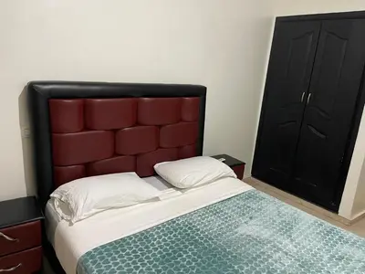 a bed with a red headboard in a bedroom at Appartement 1er étage numéro 6 POUR FAMILLE in Marrakech