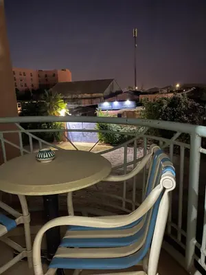 a table and a chair on a balcony at night at Appartement 1er étage numéro 6 POUR FAMILLE in Marrakech