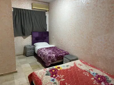 two beds in a room with purple and purple at Appartement 1er étage numéro 7 POUR FAMILLE in Marrakech