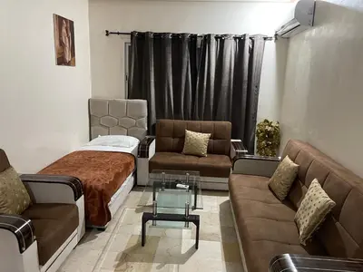 a living room with a bed and a couch at Appartement 1er étage numéro 7 POUR FAMILLE in Marrakech