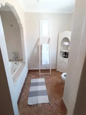 a bathroom with a tub and a toilet and a sink at Villa Mezouza in Marrakech