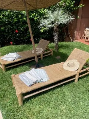 an umbrella and two chairs and a table in the grass at Villa Mezouza in Marrakech